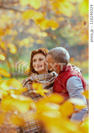 smiling modern boyfriend and girlfriend in park kissing smiling modern boyfriend and girlfriend in park kissing 116240324
