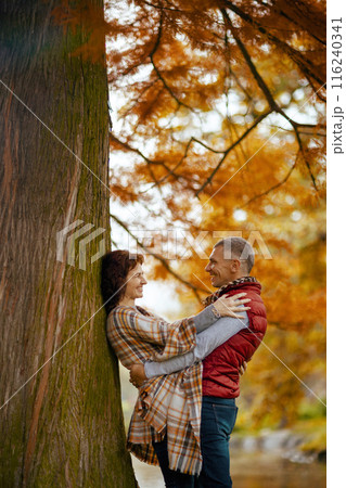 smiling romantic couple in park embracing near tree 116240341
