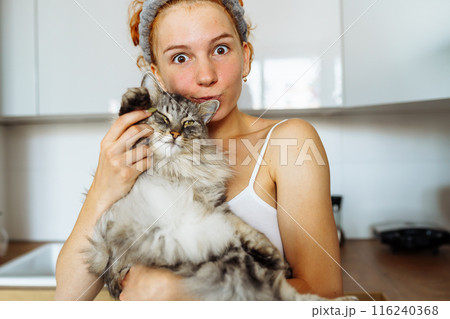 portrait red-haired teenage girl with gray fluffy cat 116240368