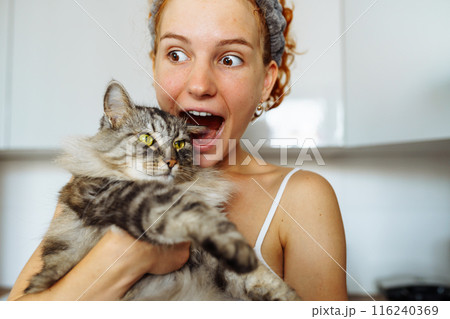portrait red-haired teenage girl with gray fluffy cat 116240369