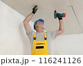 Senior adult worker fixing gypsum ceiling using screwdriver Senior adult worker fixing gypsum ceiling using screwdriver 116241126