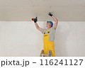 Senior adult worker fixing gypsum ceiling using screwdriver Senior adult worker fixing gypsum ceiling using screwdriver 116241127