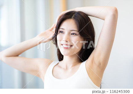 黒髪ロングヘアの若い女性（ビューティーイメージ、白いノースリーブ、窓際、自然光） 116245300