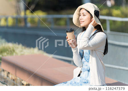 公園でテイクアウトコーヒーを飲む若い女性 公園でテイクアウトコーヒーを飲む若い女性 116247379