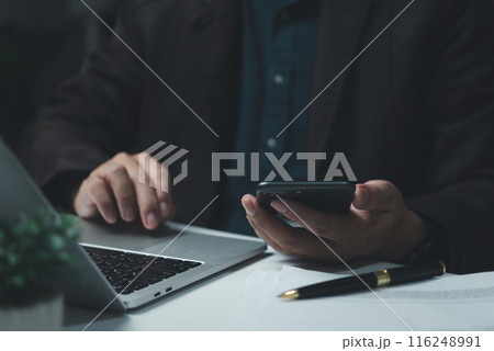 Businessman working using mobile phone on laptop computer browsing internet online modern office and technology 116248991