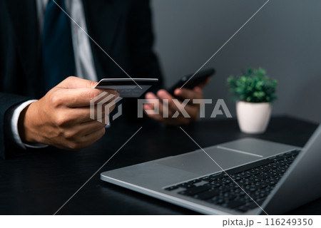 Business man holding credit card and using laptop. Online internet shopping payment. Finance and banking concept.. Business man holding credit card and using laptop. Online internet shopping payment. Finance and banking concept.. 116249350