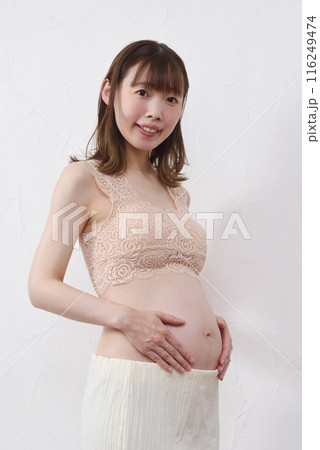 大きなお腹に手を添える日本人の若い妊婦 116249474