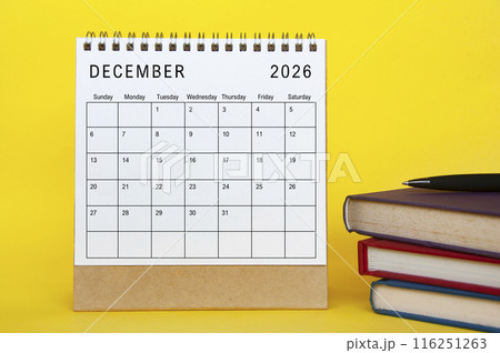 December 2026 calendar with yellow cover background and books. New month and calendar concept December 2026 calendar with yellow cover background and books. New month and calendar concept 116251263