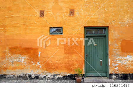 Old yellow grunge house with green door of Nyboder district in Copenhagen, Denmark 116251452