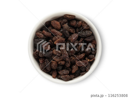 Ceramic bowl with sweet dark raisins made from red grapes isolated on white background. 116253808