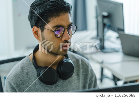 Asian man  prompt engineer develop coding app with software data sitting in front of computer monitor at office 116256069