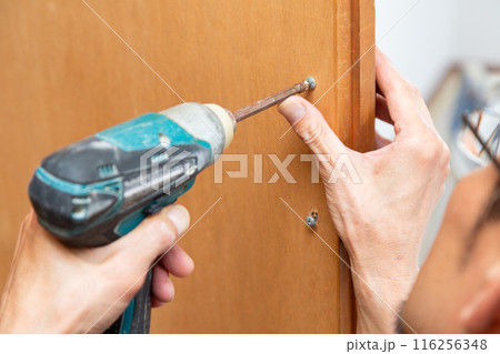 クローゼットの扉の取手を取り付ける手元 116256348