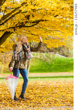Woman walking in park with umbrella 116257469