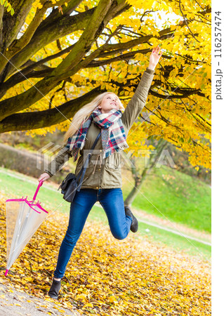 Woman walking in park with umbrella Woman walking in park with umbrella 116257474