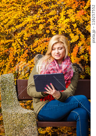 Woman relaxing sitting on bench in park using tablet 116257552