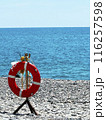 Lifebuoy on the seashore. Beach safety equipment. Positioned by water s edge for emergencies and rescue purposes 116257598
