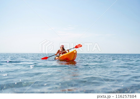 Kayak sea woman. Happy attractive woman with long hair in red swimsuit, swimming on kayak. Summer holiday vacation and travel concept. Kayak sea woman. Happy attractive woman with long hair in red swimsuit, swimming on kayak. Summer holiday vacation and travel concept. 116257884