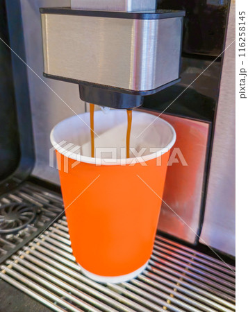 Coffee machine and orange paper cup. 116258145