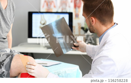 Physician doctor examining patient leg, hold x ray of bone, injury after accident Physician doctor examining patient leg, hold x ray of bone, injury after accident 116258228
