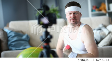 Middle aged man training with dumbbells, record on videocamera 116258973