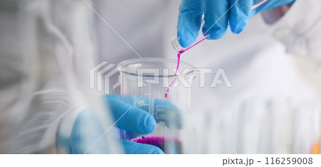 Scientist pour pink liquid from flask in medical chemistry laboratory Scientist pour pink liquid from flask in medical chemistry laboratory 116259008