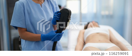 Beautician holding hybrid laser hair removal machine in beauty salon closeup Beautician holding hybrid laser hair removal machine in beauty salon closeup 116259091