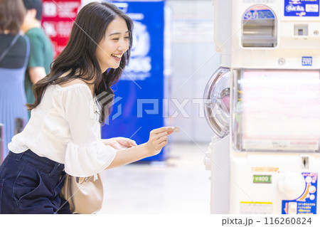 カプセルトイを楽しむ若い女性 116260824