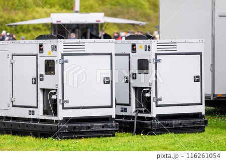 Set two large portable industrial power fuel generator green lawn at commercial event outdoors clear blue sky background. Mobile electricity supply energy plant unit backup equipment rent service Set two large portable industrial power fuel generator green lawn at commercial event outdoors clear blue sky background. Mobile electricity supply energy plant unit backup equipment rent service 116261054