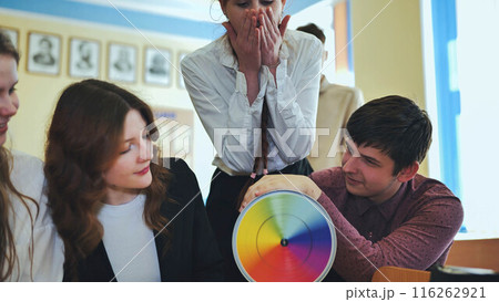 Students in physics class spin Newton's colorful wheel. 116262921