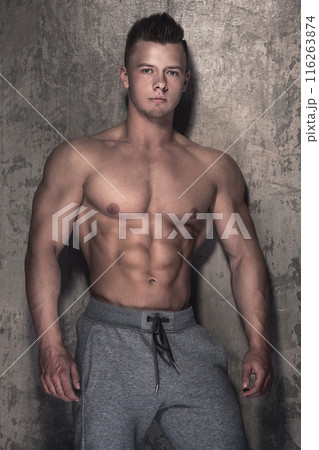 Handsome and muscular guy against concrete wall Handsome and muscular guy against concrete wall 116263874