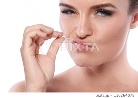 Serious woman with toothpick on white background Serious woman with toothpick on white background 116264079