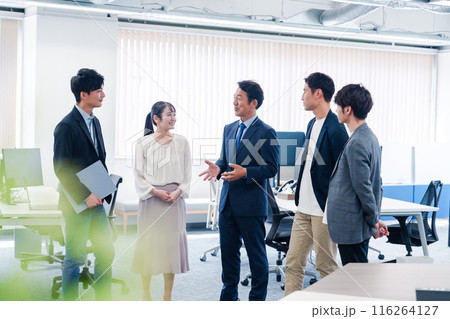オフィスで立ち話をするビジネスパーソン 116264127