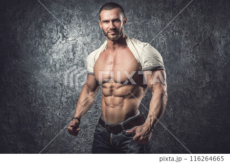 Man showing his body against concrete wall Man showing his body against concrete wall 116264665