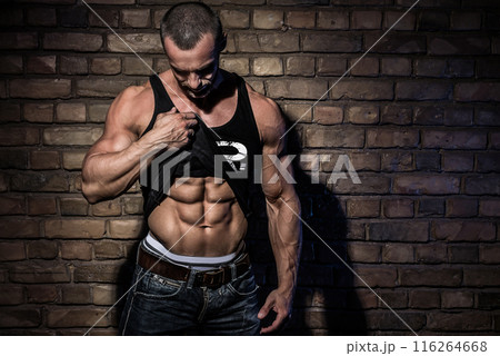 Man with muscular and sexy body against brick wall 116264668