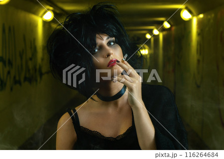Freaky woman with black hair smoking a cigarette Freaky woman with black hair smoking a cigarette 116264684