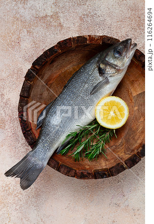 fresh, raw sea bass fish, in a wooden plate, top view, no people. fresh, raw sea bass fish, in a wooden plate, top view, no people. 116264694