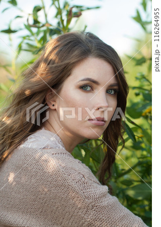 Nice young adult model woman brunette with long wavy hairstyle and natural make-up 116264955