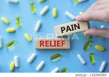Pain Relief symbol. Concept word Pain Relief on wooden blocks. Beautiful blue background with pills. Doctor Hand. Medicine and Pain Relief concept. Copy space Pain Relief symbol. Concept word Pain Relief on wooden blocks. Beautiful blue background with pills. Doctor Hand. Medicine and Pain Relief concept. Copy space 116266309