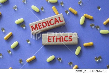 Medical Ethics symbol. Concept word Medical Ethics on wooden blocks. Beautiful purple background with pills. Medicine and Medical Ethics concept. Copy space Medical Ethics symbol. Concept word Medical Ethics on wooden blocks. Beautiful purple background with pills. Medicine and Medical Ethics concept. Copy space 116266730