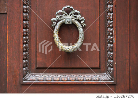 Leuven, Flanders, Belgium - Decorated antique door handle on a brown wooden door 116267276
