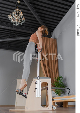 Foot work and core exercise on a Balanced Body Chair machine illuminated by sunlight 116269169