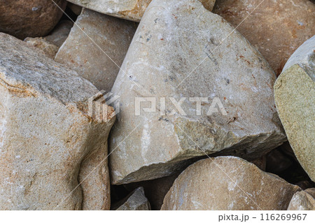 Closeup of smooth river rocks displaying a variety of warm tones and textures 116269967
