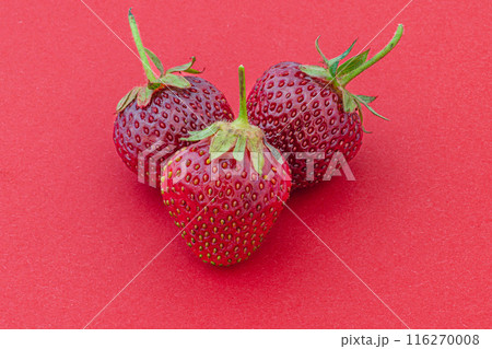 Ripe fresh strawberries on a red background Ripe fresh strawberries on a red background 116270008