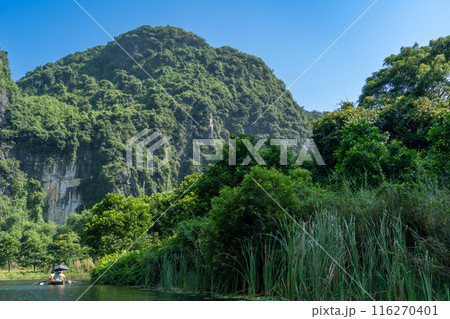 ベトナムハノイ 渓谷の川を手漕ぎのボートで進むニンビンのボートツアーの観光客 ベトナムハノイ 渓谷の川を手漕ぎのボートで進むニンビンのボートツアーの観光客 116270401