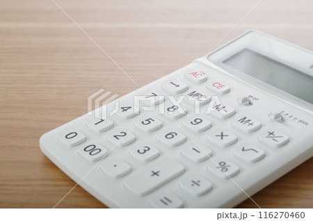 テーブルの上に置かれた電卓 116270460
