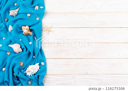 Seashells, blue fabric and starfish on white planks vacation planning background flat lay with copy-space 116275306