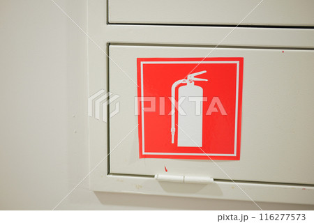The store aisle is marked with a sign indicating the presence of a fire extinguisher and fire hose 116277573