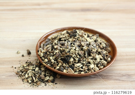 Dried roots of comfrey, lat. Symphytum officinale on wood table. 116279619