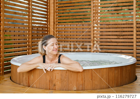 Portrait of carefree happy smiling woman relaxing at hot tub during her vacation 116279727