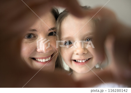 Closeup mother and daughter showing heart symbol with joined fingers 116280142